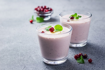 Healthy cranberry cpiced banana smoothie on concrete or stone background. Selective focus, copy space, close up. 