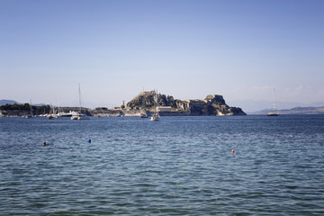 Obraz premium View of historical fortress and yachts in Corfu (Kerkyra). It's an island off Greece’s northwest coast in the Ionian Sea. Its cultural heritage reflects Venetian, French and British rule.