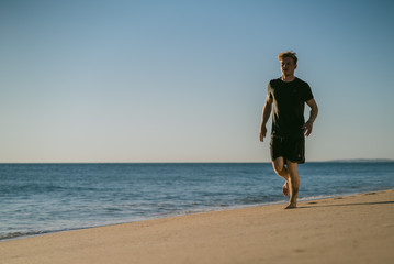 Man running on a beach at sunset in Portugal