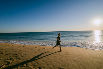 Man running on a beach at sunset in Portugal