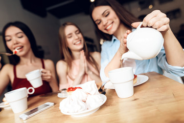 Three girls are sitting together in a cafe.