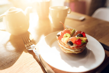 Sweet cake on the table in the cafe. The cake is made from cream and fruits.