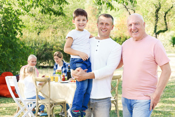 Happy family having barbecue party outdoors