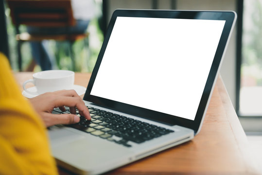 Business Technology Concepts - Digital lifestyle working outside office. Woman hands typing laptop computer with blank screen on table in coffee shop. Blank laptop screen mock up for display of design