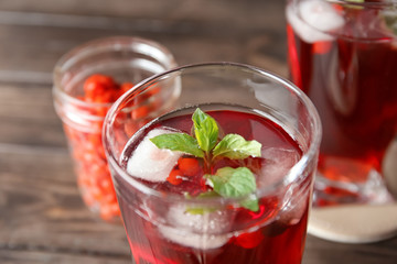 Glass with healthy goji juice on wooden table