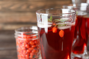 Glass with healthy goji juice on table