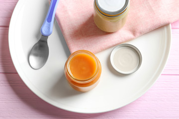 Jars with healthy baby food on wooden table