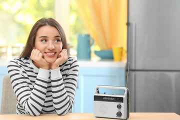 Young woman listening to radio in kitchen