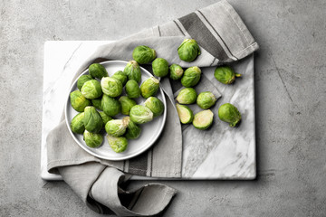 Plate with fresh raw Brussels sprouts on table
