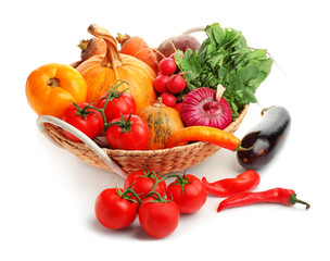 Basket and fresh vegetables on white background