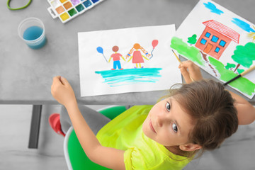 Little girl painting at table