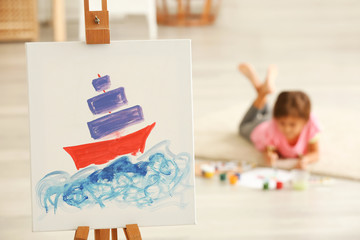 Easel and canvas with beautiful picture in room