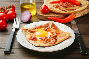 Tasty thin buckwheat pancake with egg on plate