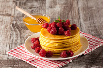 Fresh made delicious pancakes with berries, blackberries, raspberries, banana, honey and maple syrup. Healthy morning breakfast concept.