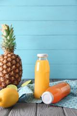Bottles of fresh juices and ingredients on table