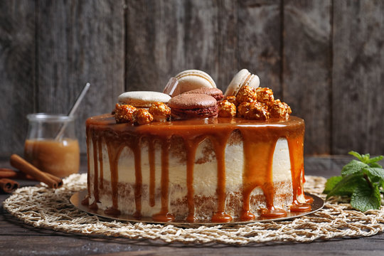 Delicious Caramel Cake On Wicker Napkin Against Wooden Wall