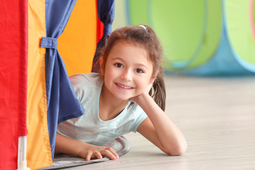 Cute little girl playing in kindergarten