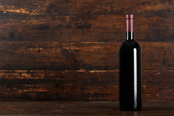 closed bottle of wine on a wooden background