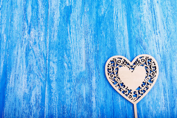 wooden heart carved on a blue wooden background. space for text