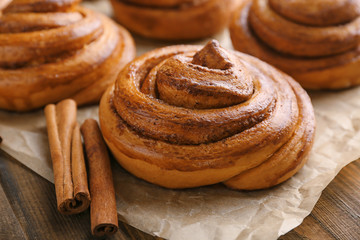 Sweet cinnamon roll on wooden table