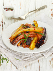 Roasted carrots with rosemary, coarse sea salt and pepper. Colorful vegetables and spices. Vegetarian dish. Selective focus