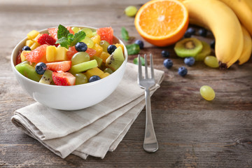 Bowl with delicious fruit salad on table