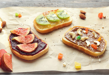 Delicious toasts with jam and chocolate paste on parchment