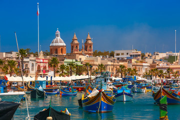 Traditional eyed colorful boats Luzzu in the Harbor of Mediterranean fishing village Marsaxlokk,...