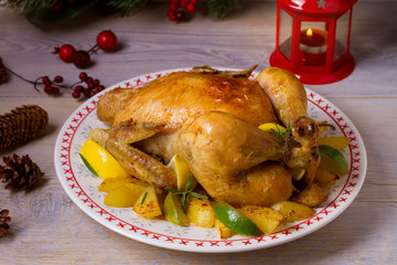 Whole roasted chicken or turkey with potatoes, lemons and limes on Christmas and New Year background, horizontal