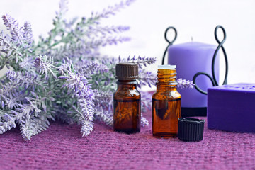 Bottles of essential oil, soap and candle with lavender