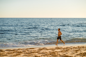 Fototapeta na wymiar Man running on the beach at sunset