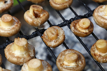 White champignons mushrooms on grill