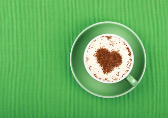 Close up latte cappuccino coffee in cup on green