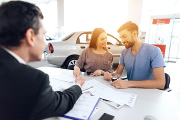 Fototapeta premium A young family came to the car showroom to choose a new car.