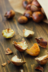 Peeled roasted chestnuts with paper cornet on table