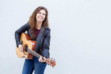 Smiling Young Woman Playing Guitar