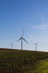 white wind power plants in a field
