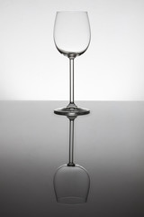 Empty wine glasses standing on a reflective surface with perfect reflection