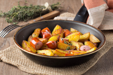 Fried potatoes with sausage in frying pan, tatsy, homemade, simple food, rustic style