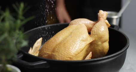 Male chef preparing roast chicken with orange and rosemary
