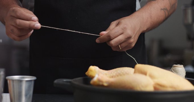 Male chef preparing roast chicken with orange and rosemary