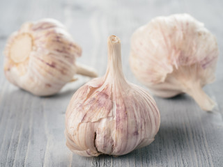 Three garlic bulb close up on gray wooden table