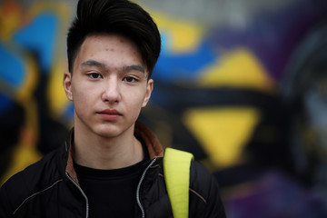 Asian young man on the street posing at the camera
