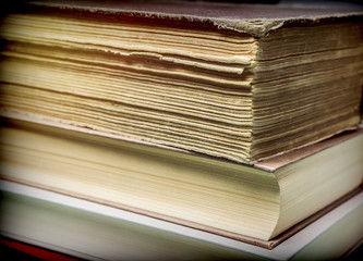 Several old books with pages worn stacked, conceptual image