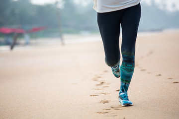 Woman is jogging along the seashore on an overcast day