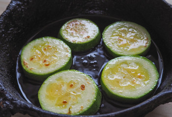 Appetizing fried zucchini in an old pan. 