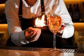 Bartender making a fresh burning cocktail with fire