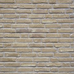 square part of yellow creme brick wall with cement joints