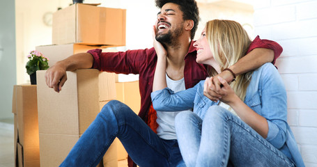 Young couple Moving in new home and unpacking carboard boxes