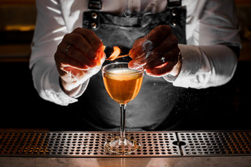 Barman hands making a fresh alcoholic drink with a smoky note
